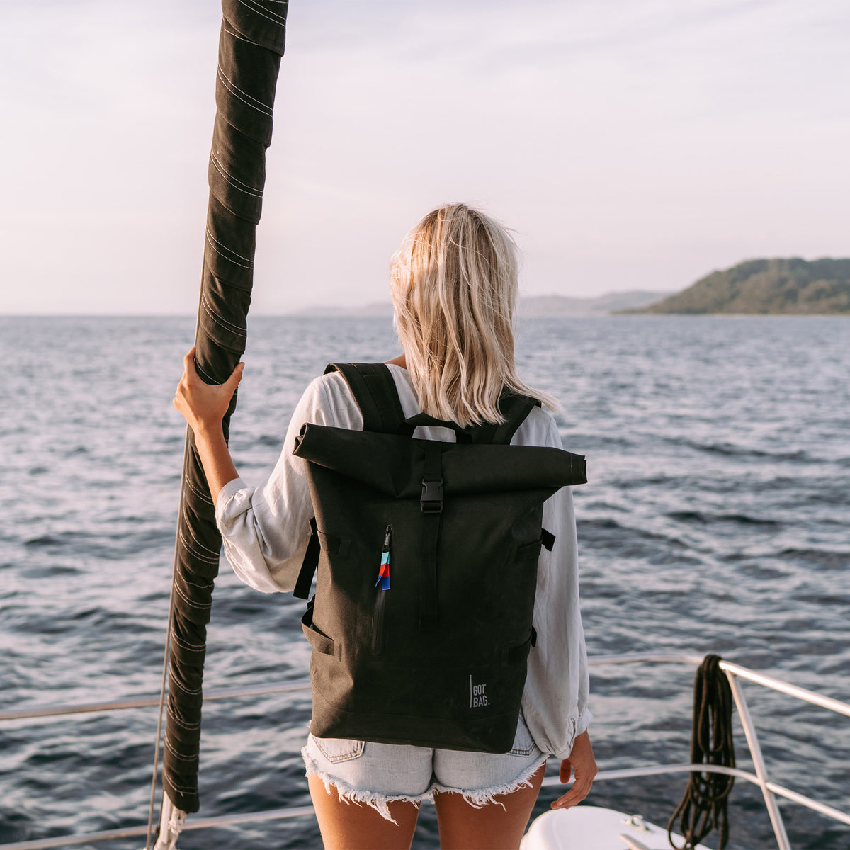 ROLLTOP Rucksack in black (Schwarz) von einer Frau auf dem Rücken getragen.