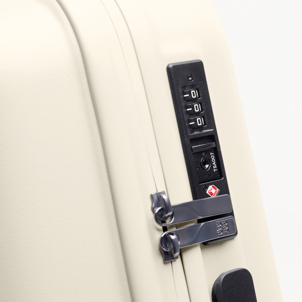 RE SHELL Cabin Koffer in soft shell (warmes Cremeweiß) als Detailaufnahme des TSA-Schlosses.