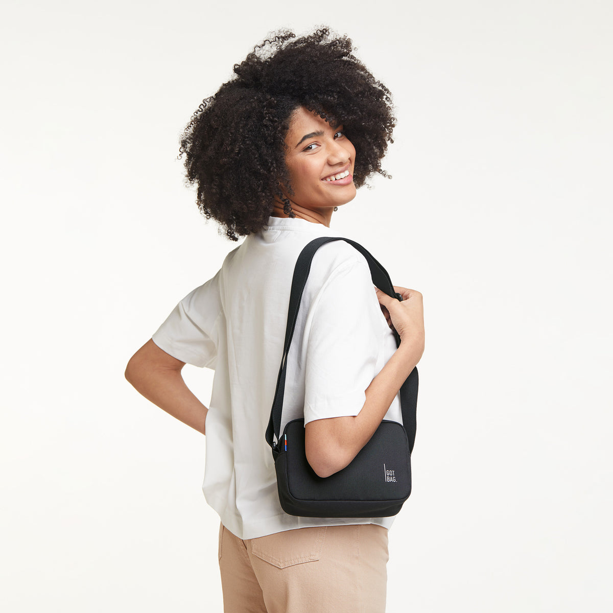 CROSSBODY Tasche in black (Schwarz) von einer Frau crossbody getragen.
