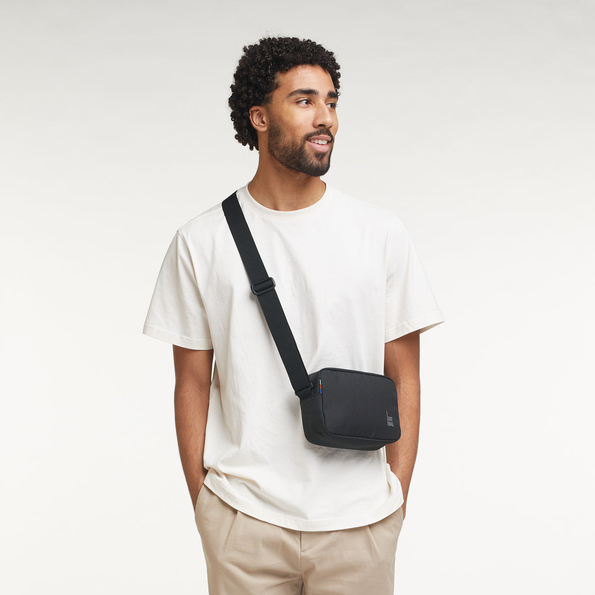 CROSSBODY Tasche in black (Schwarz) von einem Mann crossbody getragen.