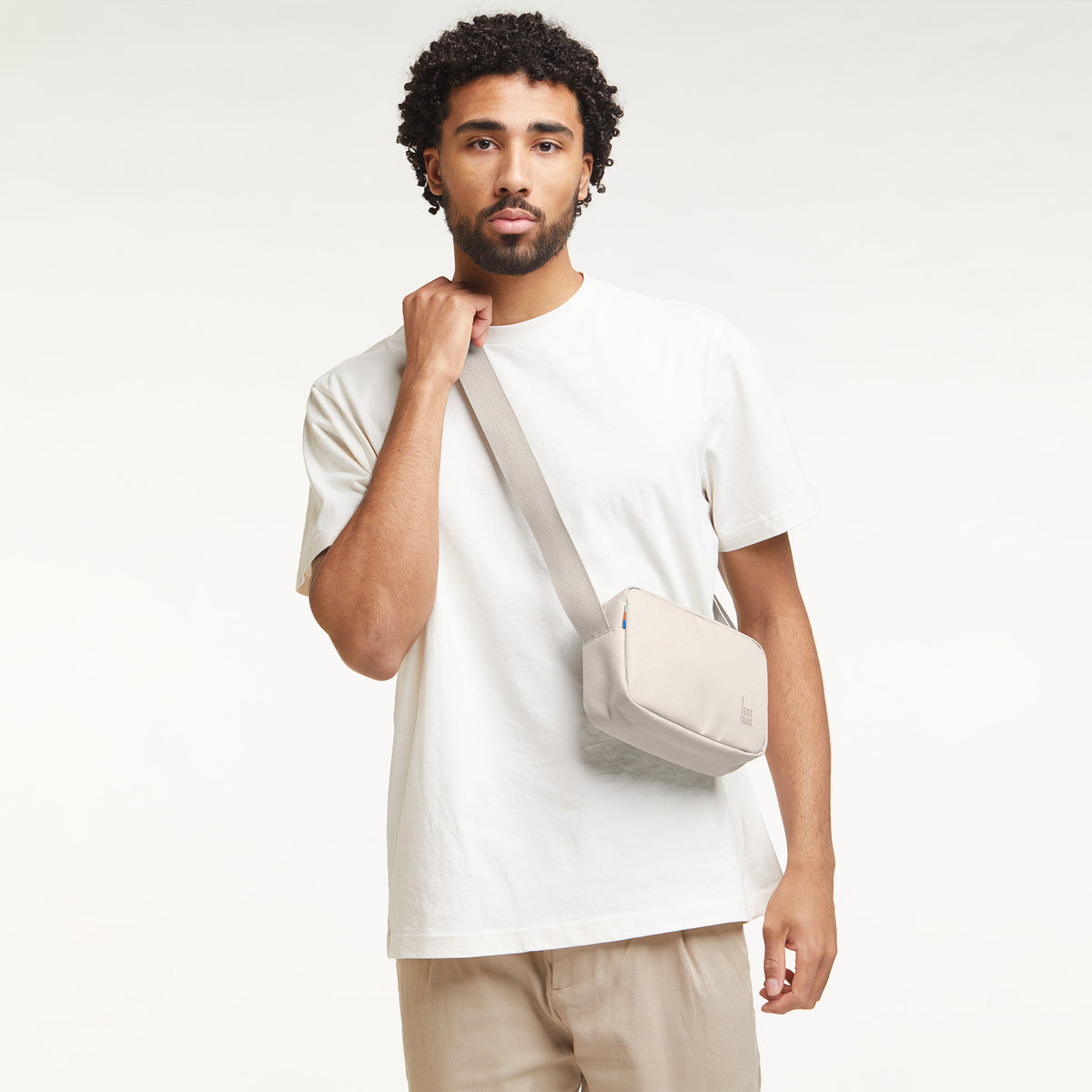 CROSSBODY Tasche in soft shell (warmes Cremeweiß) von einem Mann crossbody getragen.
