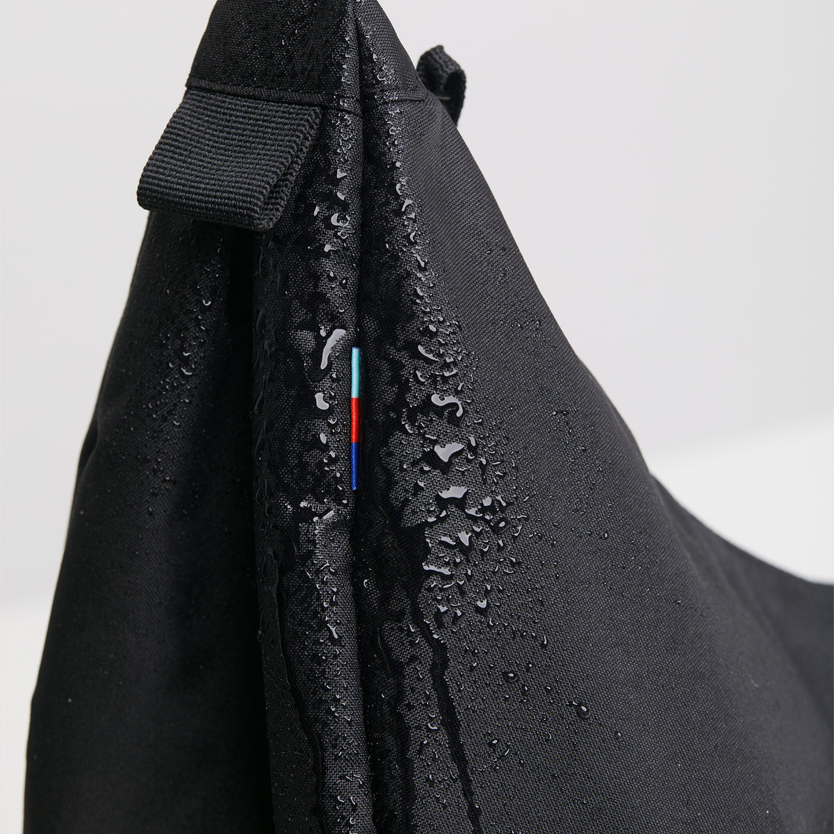 MOON BAG LARGE Tasche in black (Schwarz) mit Wassertropfen und farbigem Detail.