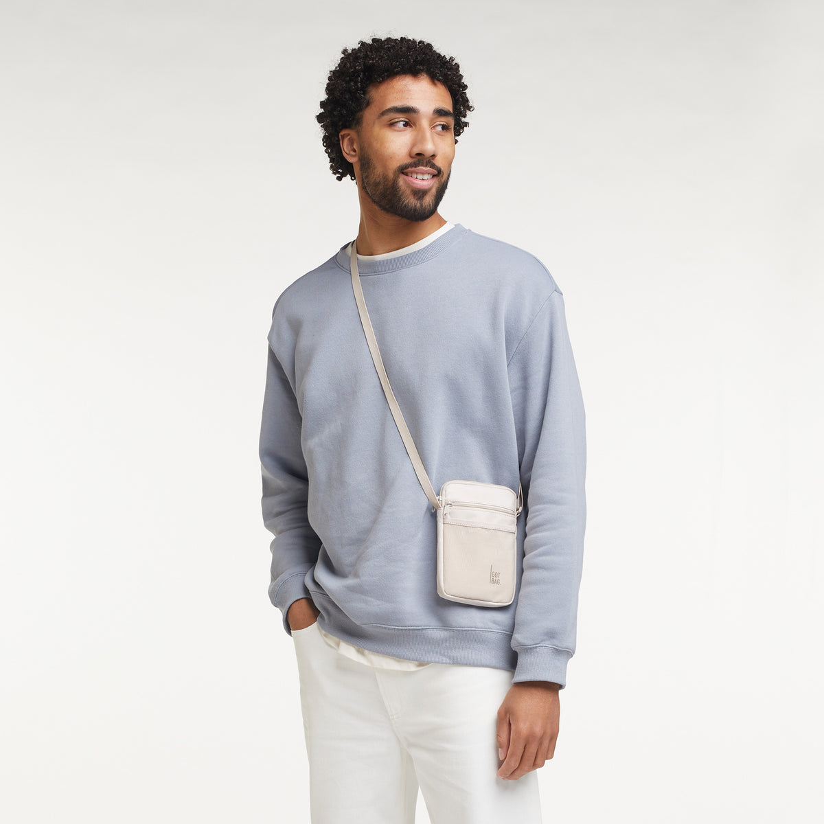 NANO BAG Tasche in soft-shell (warmes Cremeweiß) von einem Mann crossbody getragen.