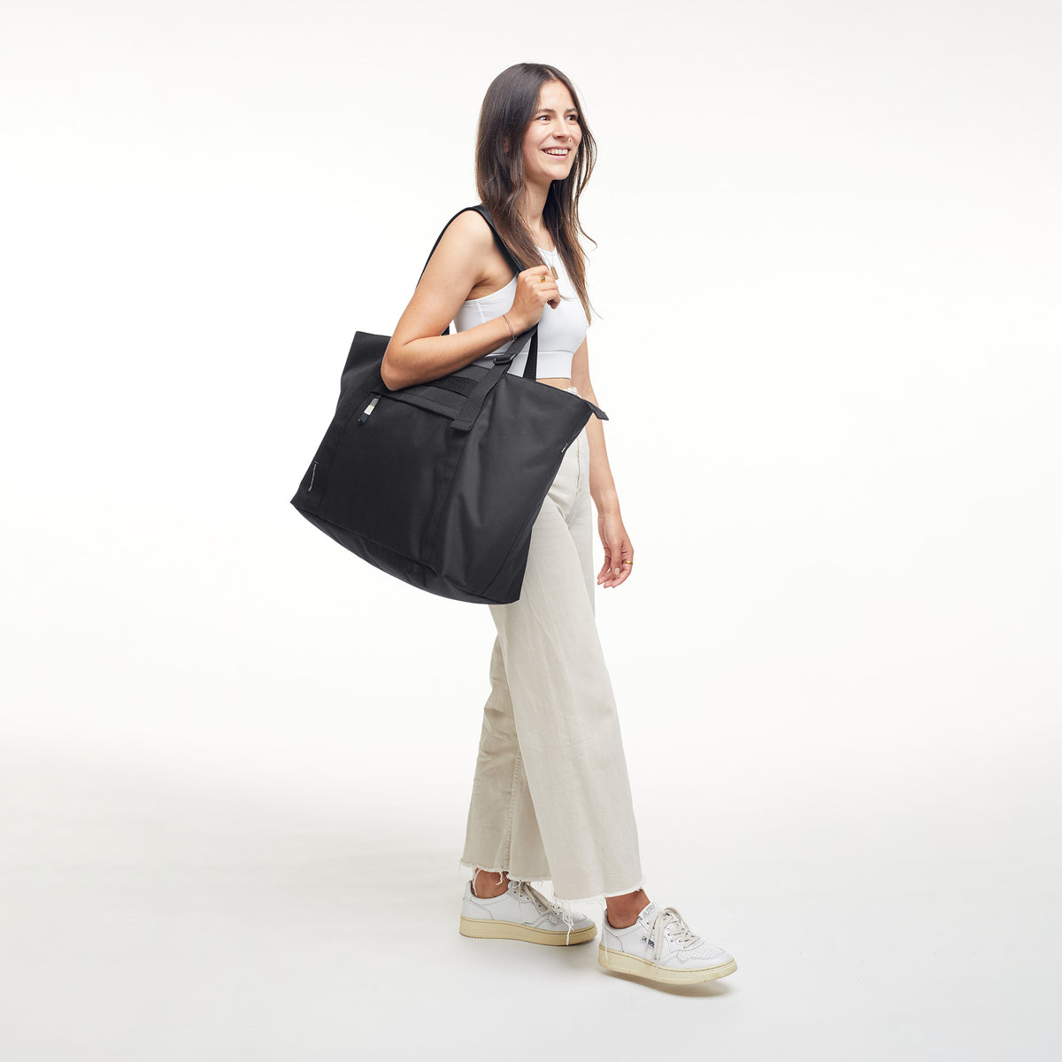 TOTE BAG Monochrome Edition Tasche in black (Schwarz) von einer Frau über der Schulter getragen.