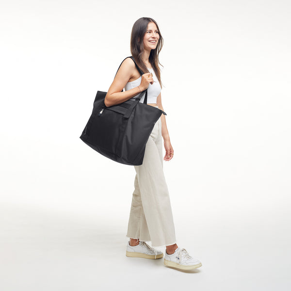 TOTE BAG Monochrome Edition borsa in black (nero) portata a tracolla da una donna.