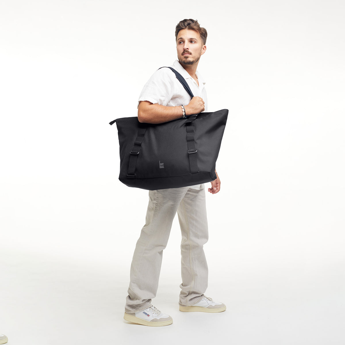 TOTE BAG MONOCHROME EDITION Tasche in black (Schwarz) von einem Mann über der Schulter getragen.