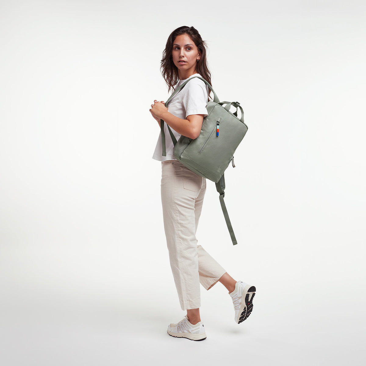 DAYPACK Rucksack in bass (Salbeigrün) von einer Frau als Rucksack auf dem Rücken getragen.