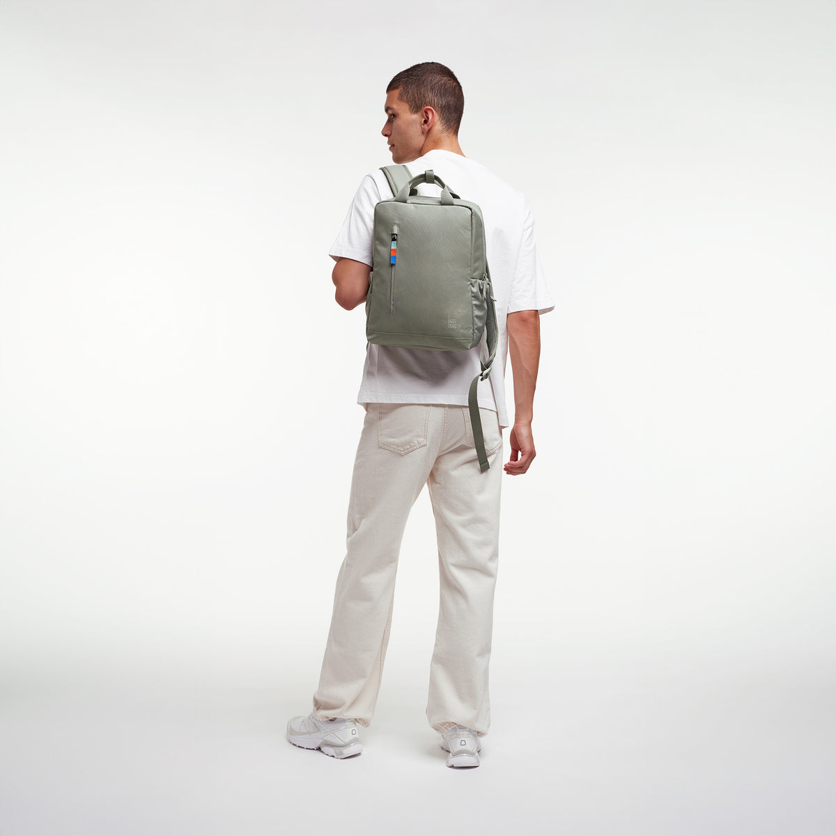 DAYPACK 2.0 Rucksack in bass (Salbeigrün) von einem Mann auf dem Rücken getragen.