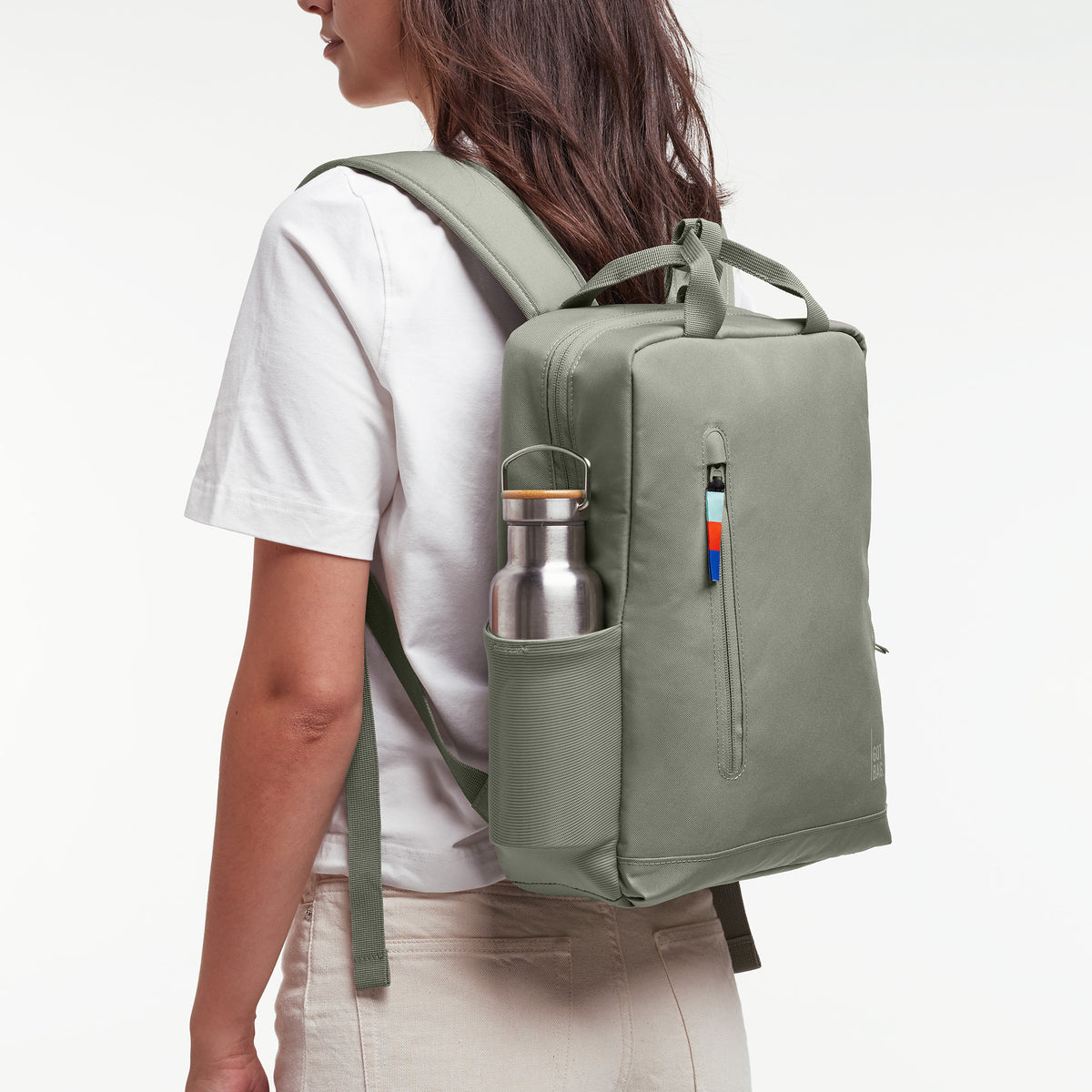 DAYPACK 2.0 Rucksack in bass (Salbeigrün) von einer Frau auf dem Rücken getragen.