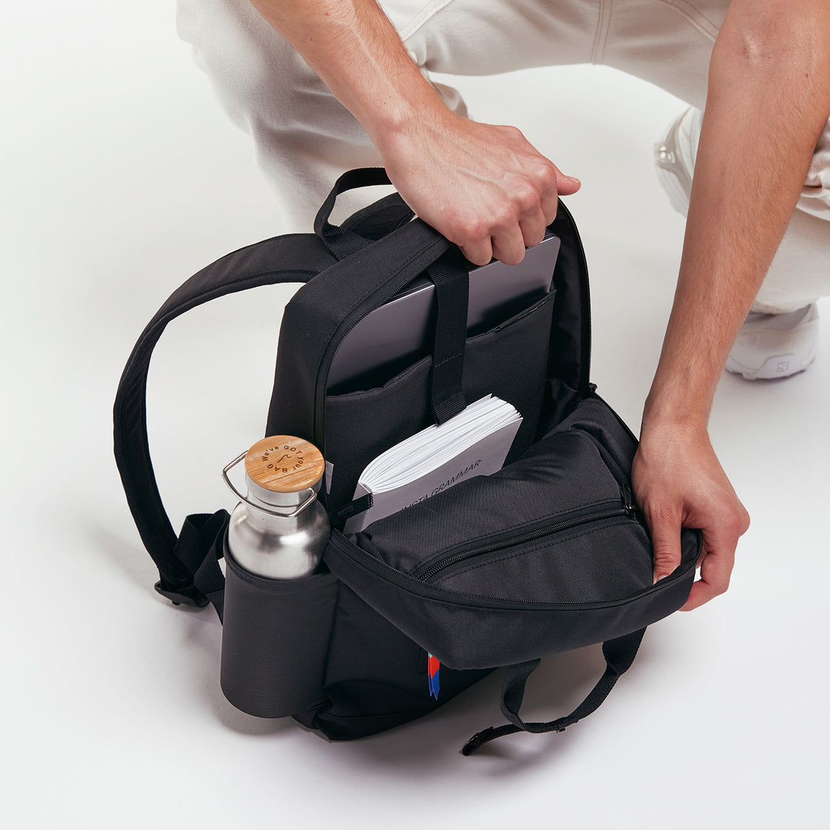 DAYPACK Rucksack in black (Schwarz) wird von einem Mann befüllt.