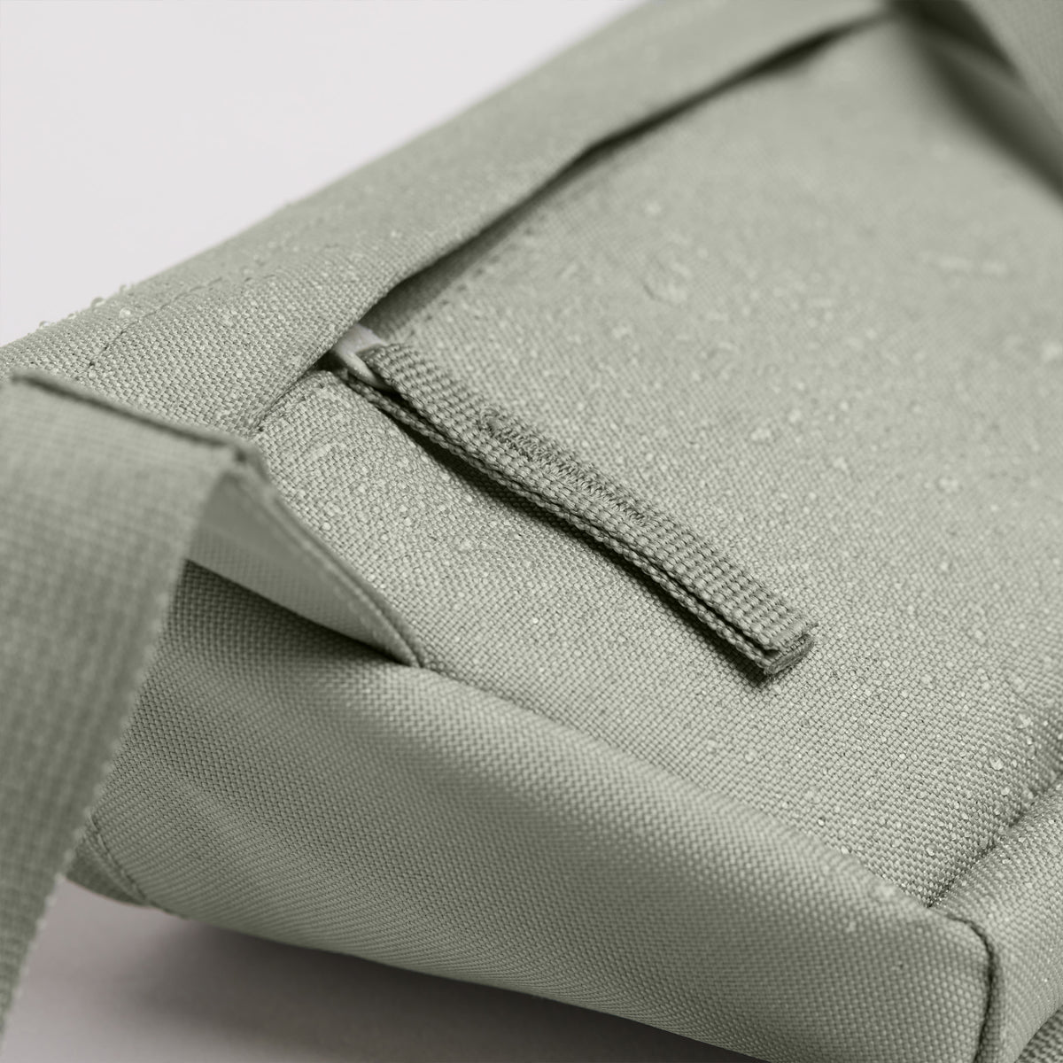 HIP BAG Tasche in bass (Salbeigrün) Detailaufnahme mit Wassertropfen.