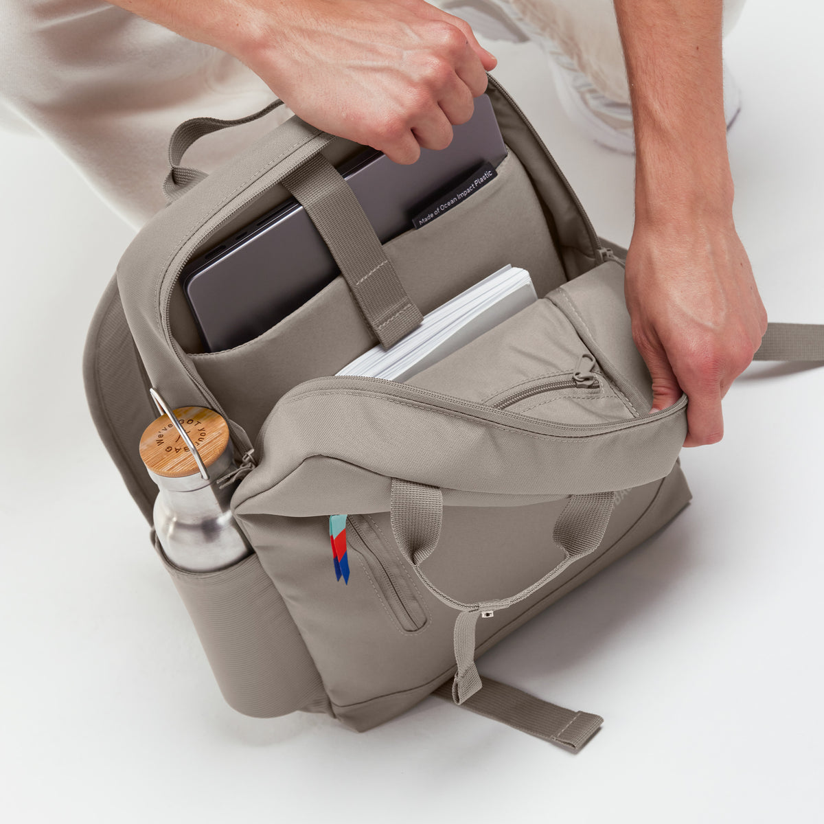 DAYPACK 2.0 Rucksack in scallop (helles Beige) von einem Mann befüllt.