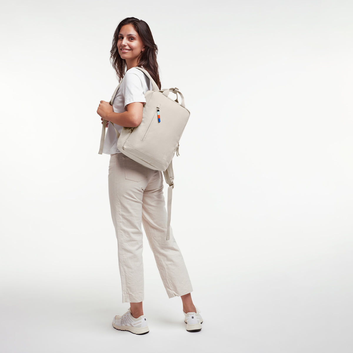 DAYPACK 2.0 Rucksack in soft shell (warmes Cremeweiß) von einer Frau als Rucksack auf dem Rücken getragen.
