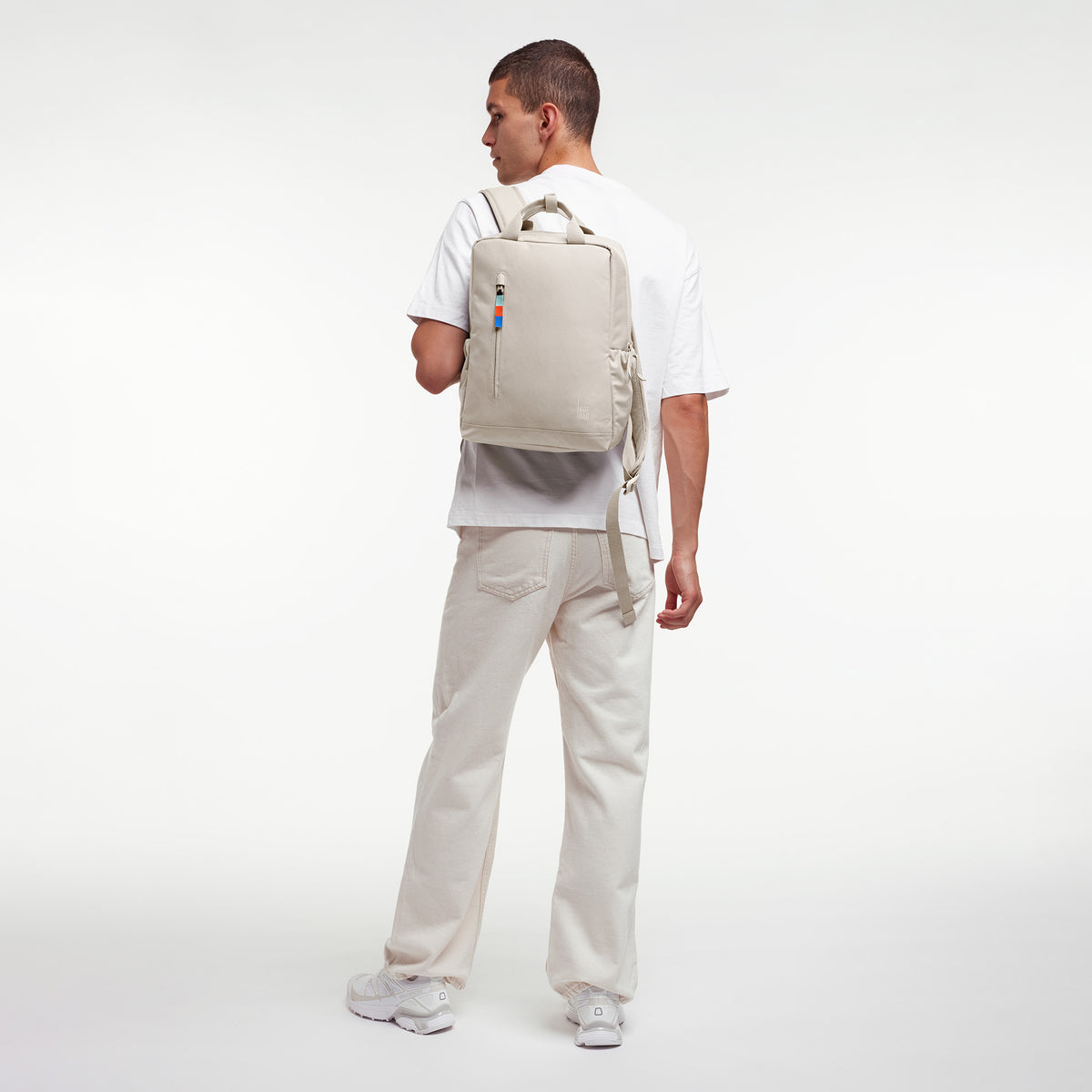 DAYPACK 2.0 Rucksack in soft shell (warmes Cremeweiß) von einem Mann auf dem Rücken getragen.