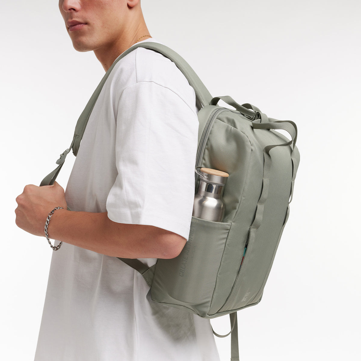 DAYPACK LOOP Rucksack in bass (Salbeigrün) von einem Mann auf dem Rücken getragen.