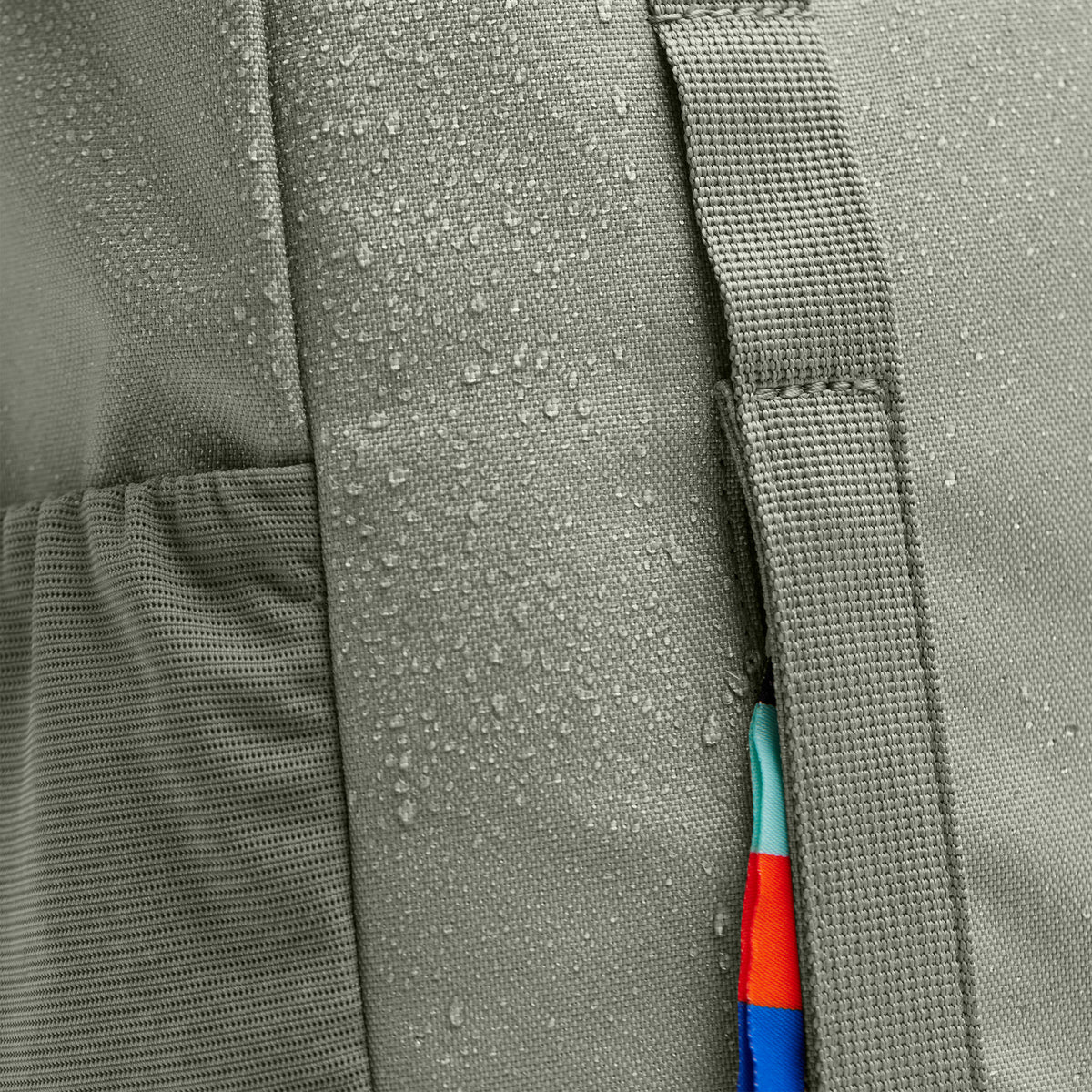 DAYPACK LOOP Rucksack in bass (Salbeigrün), Detailaufnahme mit Wassertropfen und farbigem Reißverschlussband.
