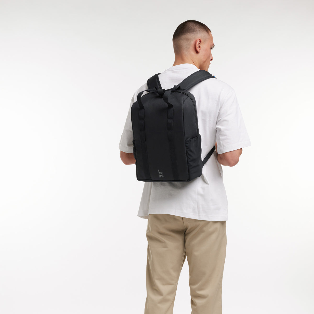 DAYPACK LOOP Rucksack in black (Schwarz) von einem Mann auf dem Rücken getragen.