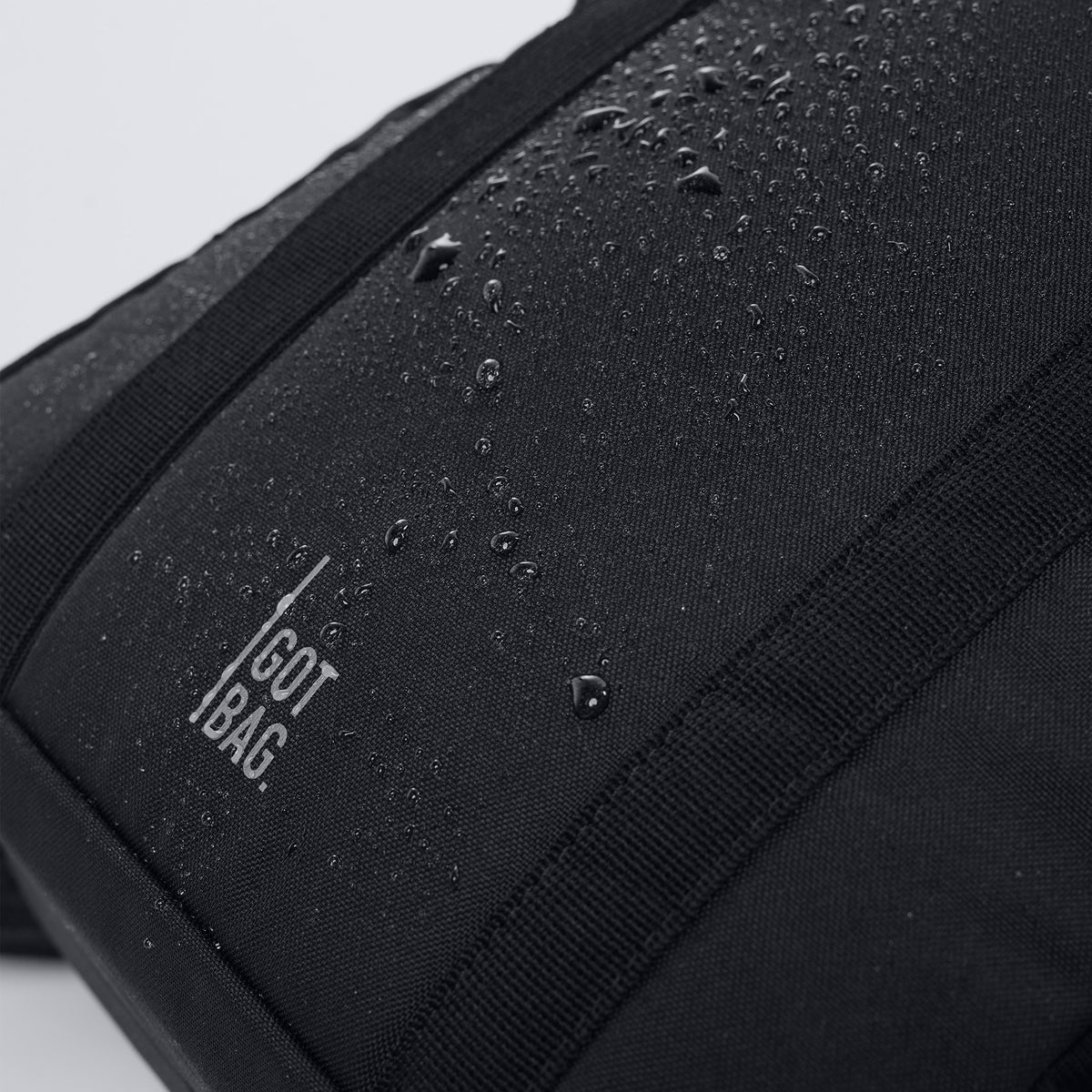 DAYPACK LOOP Rucksack in black (Schwarz) als Detailaufnahme mit Wassertropfen auf der Oberfläche.