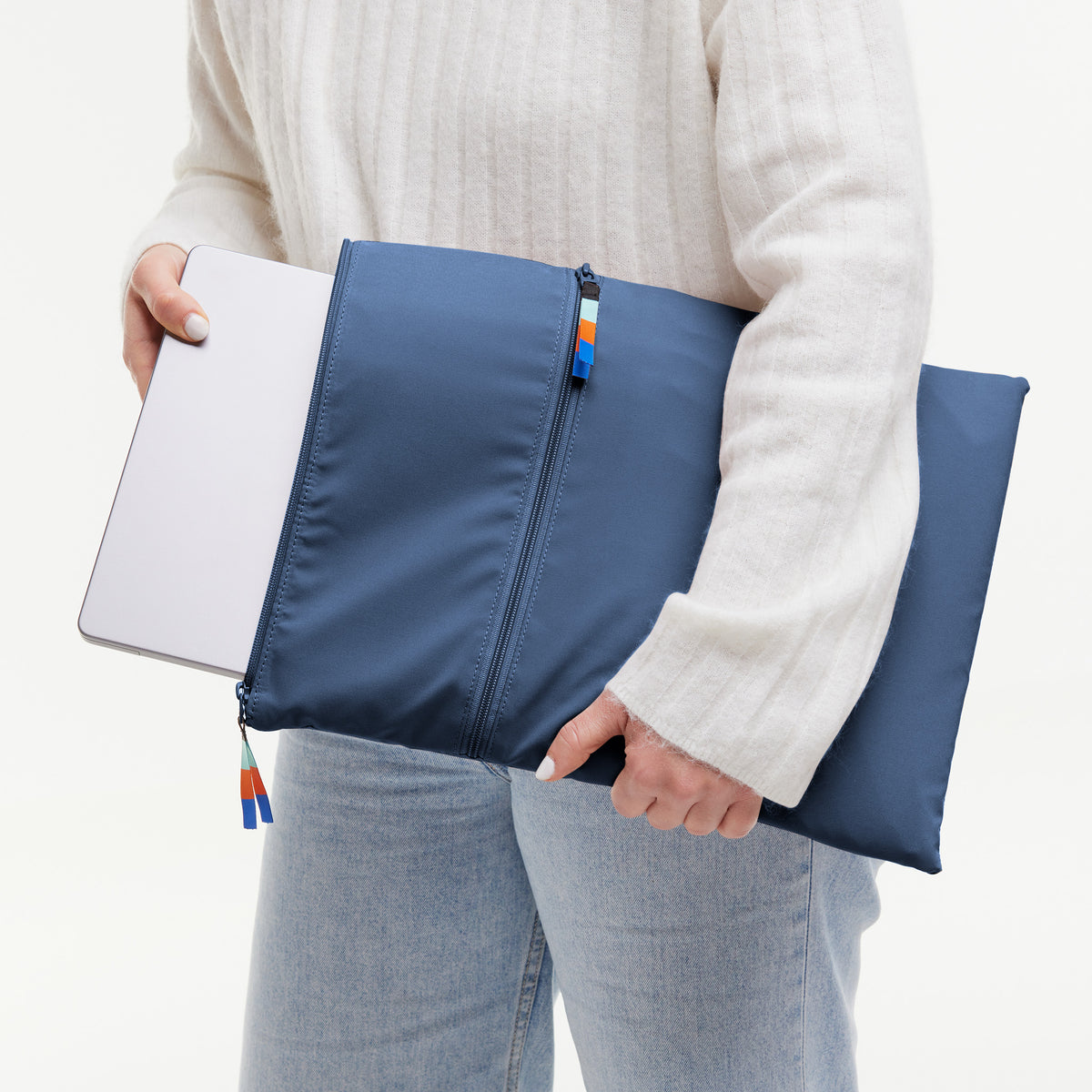 ROLLTOP LITE 2.0 Tasche, die von einer Frau gehalten wird, während sie einen Laptop hineinschiebt.