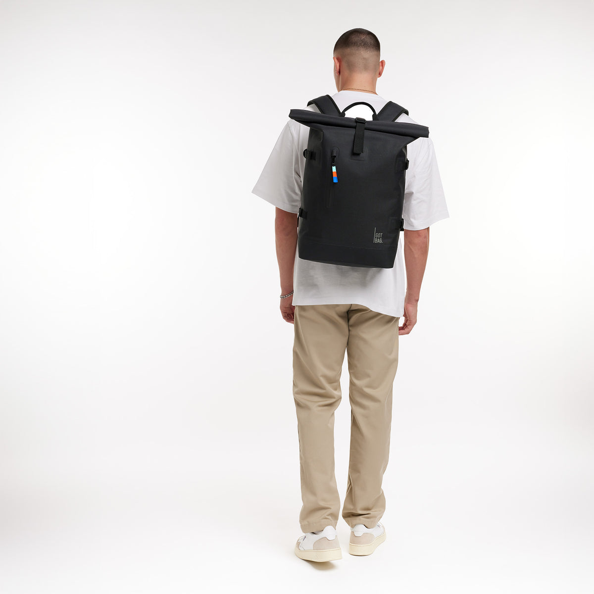 ROLLTOP 2.0 Rucksack in black (Schwarz) von einem Mann als Rucksack auf dem Rücken getragen.