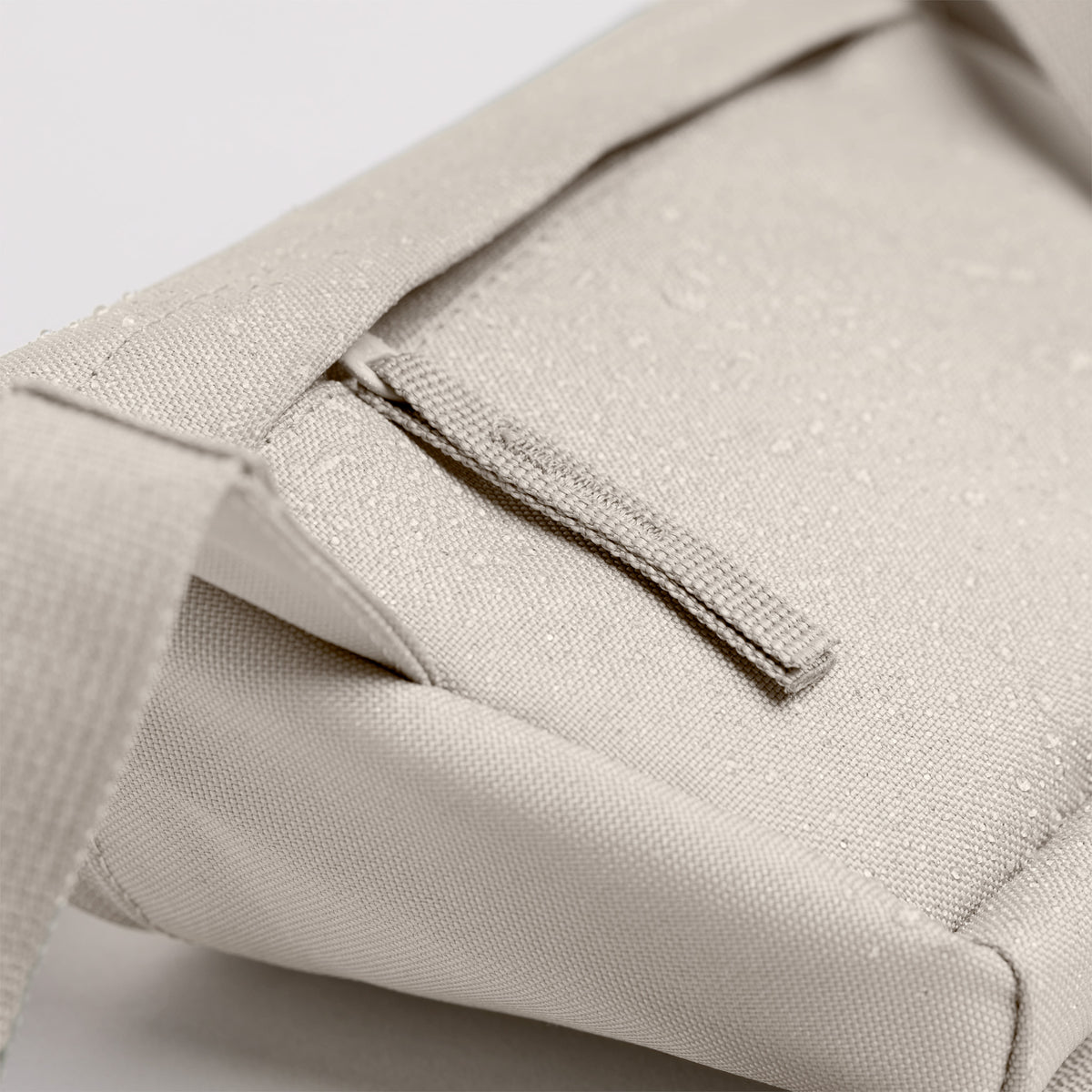 HIP BAG Tasche in soft shell (warmes Cremeweiß) mit Wassertropfen auf der Oberfläche.