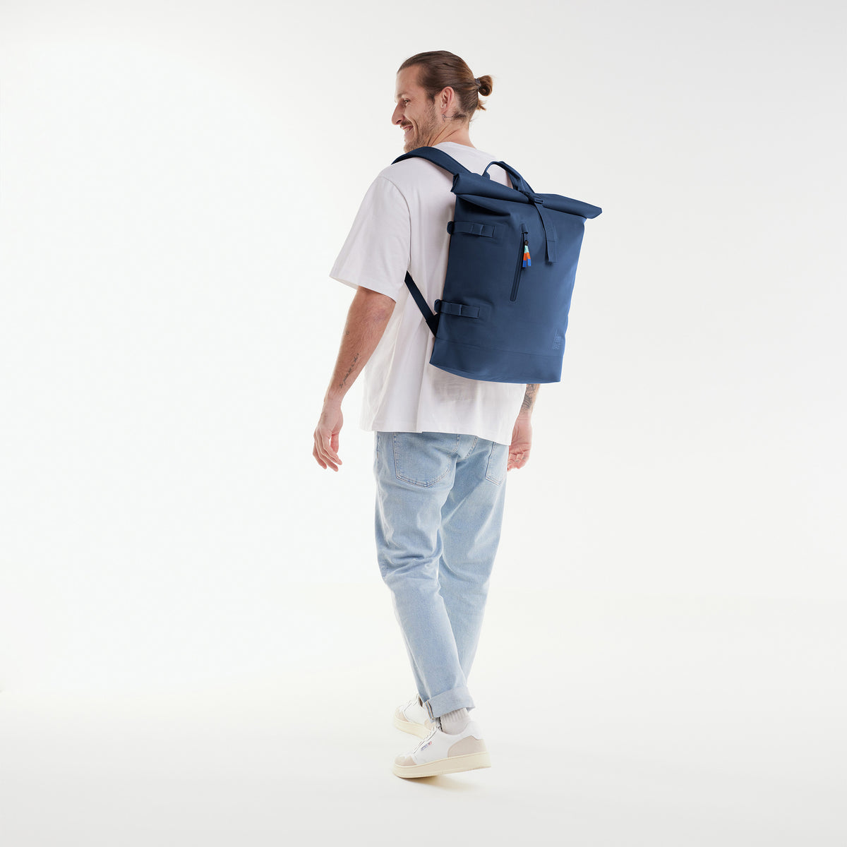 ROLLTOP Rucksack in ocean von einem Mann auf dem Rücken getragen.