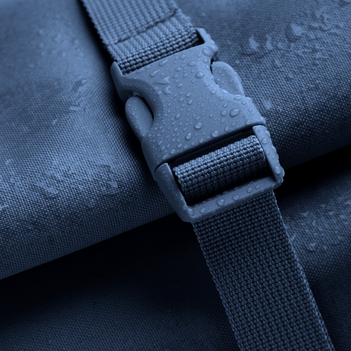 ROLLTOP Rucksack als Detailaufnahme mit Wassertropfen auf Schnalle und Stoff.