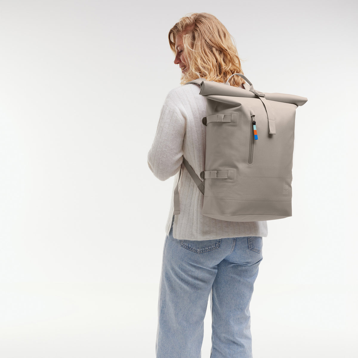ROLLTOP 2.0 Rucksack in scallop (helles Beige) von einer Frau als Rucksack auf dem Rücken getragen.