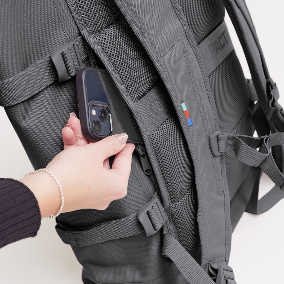 ROLLTOP 2.0 Rucksack in shark (Dunkelgrau), eine Frau öffnet eine Reißverschlusstasche.