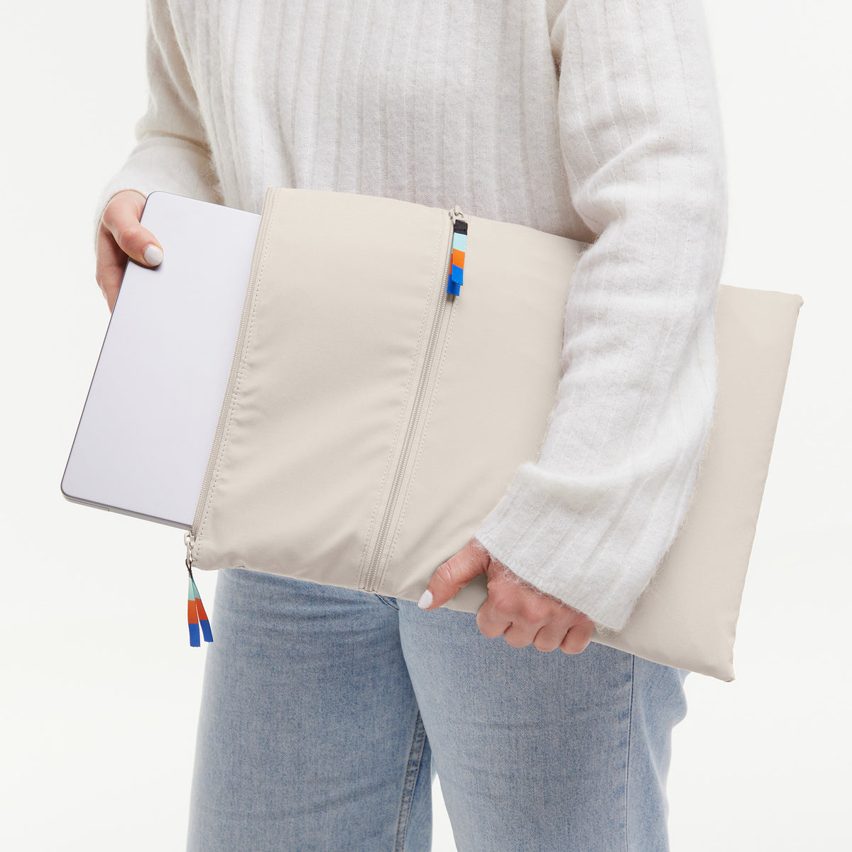 ROLLTOP 2.0 Tasche in soft shell (warmes Cremeweiß) von einer Frau in der Hand gehalten.