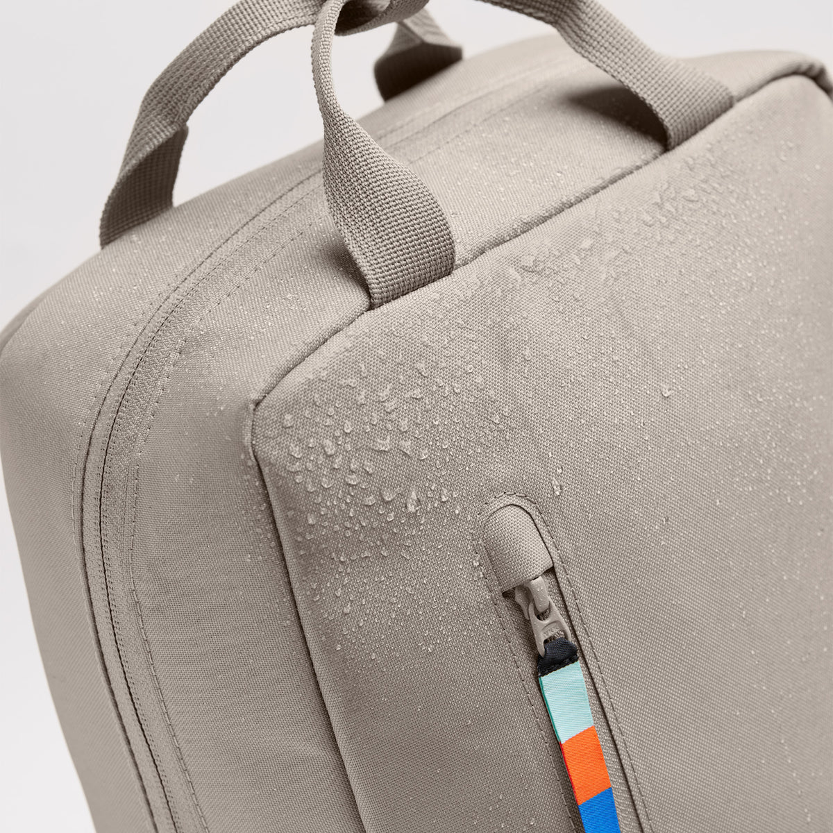 DAYPACK 2.0 Rucksack in scallop (helles Beige), Detailansicht mit Wassertropfen auf dem Stoff.