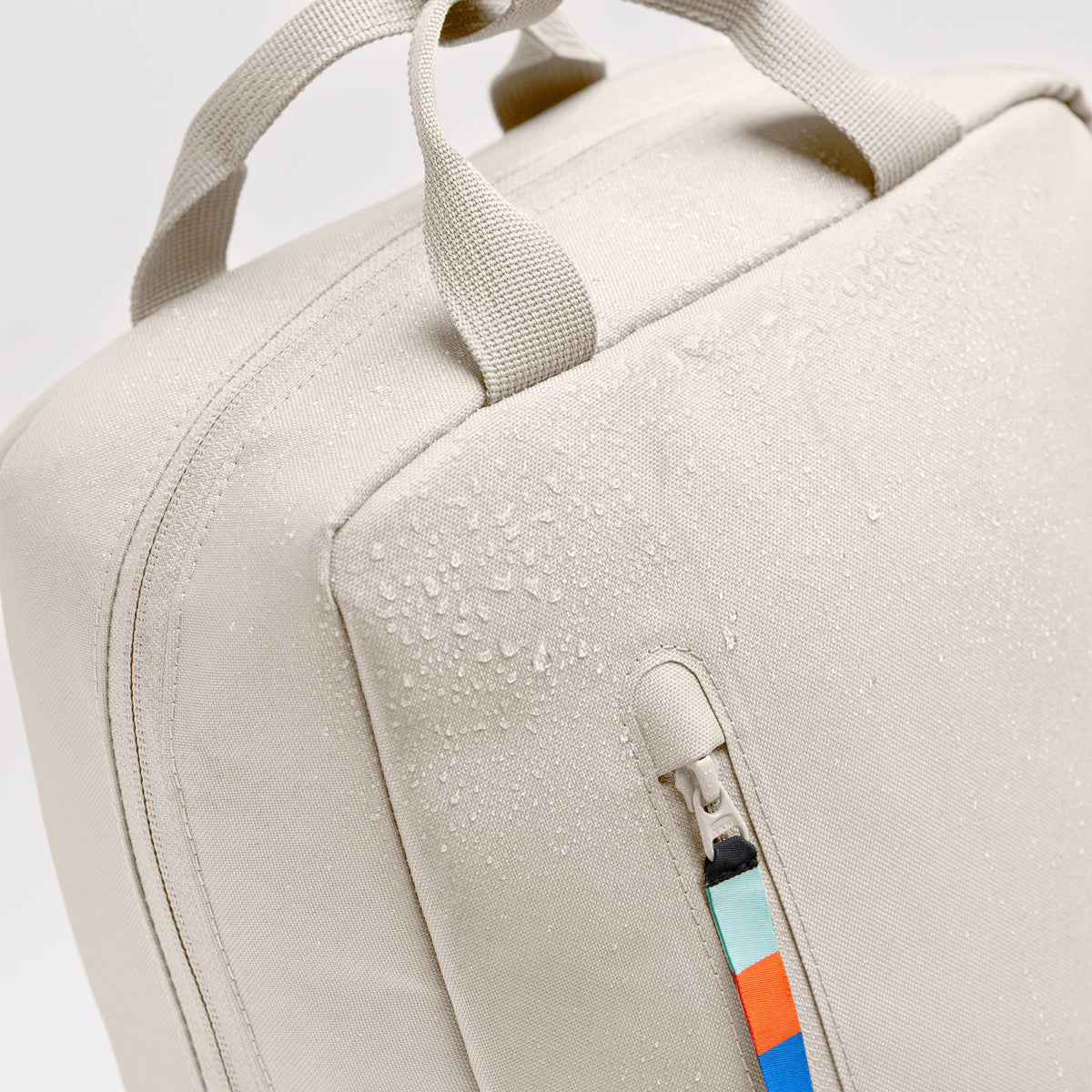 DAYPACK Rucksack in soft shell (warmes Cremeweiß), Detailaufnahme mit Wassertropfen auf dem Stoff.