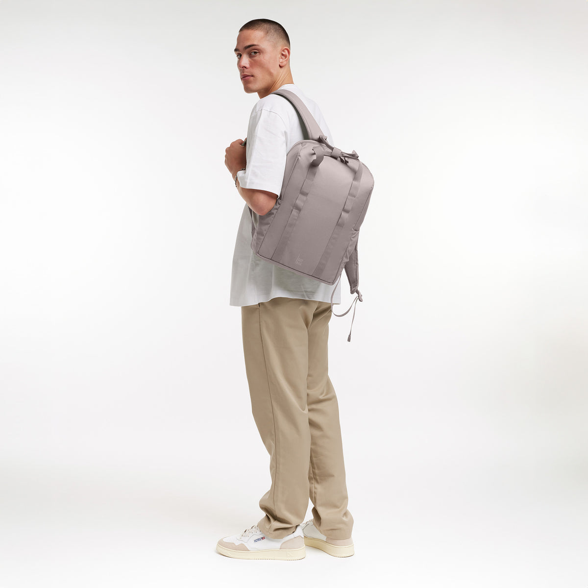 DAYPACK LOOP Rucksack in seahorse (graues Pastellrosa) von einem Mann als Rucksack auf dem Rücken getragen.