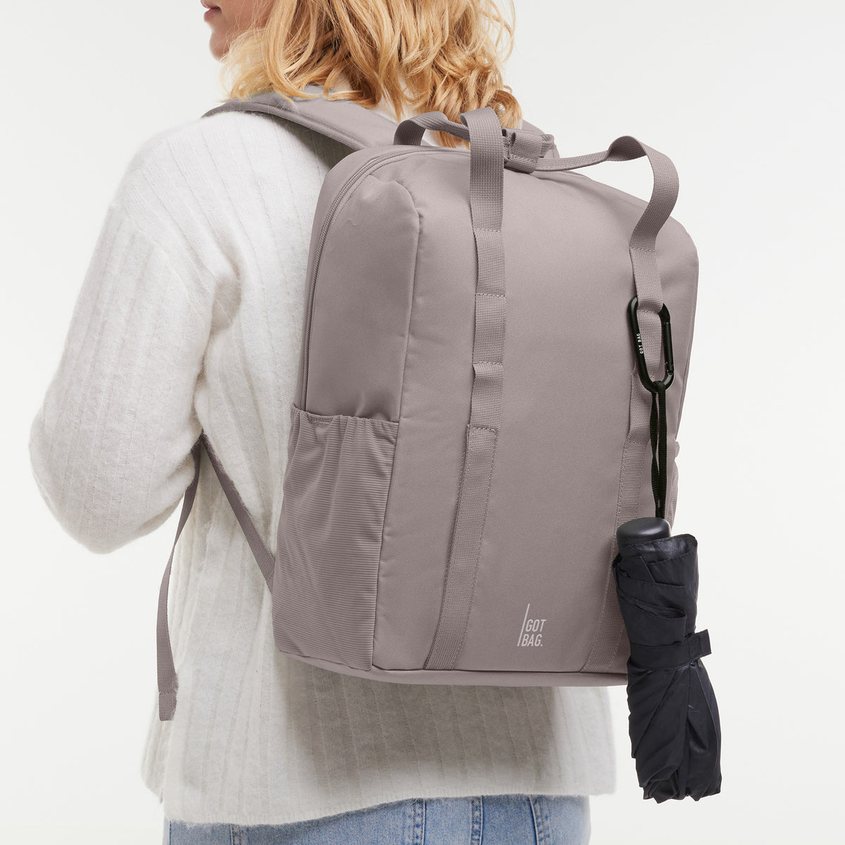 DAYPACK LOOP Rucksack in seahorse (graues Pastellrosa) von einer Frau als Rucksack auf dem Rücken getragen.