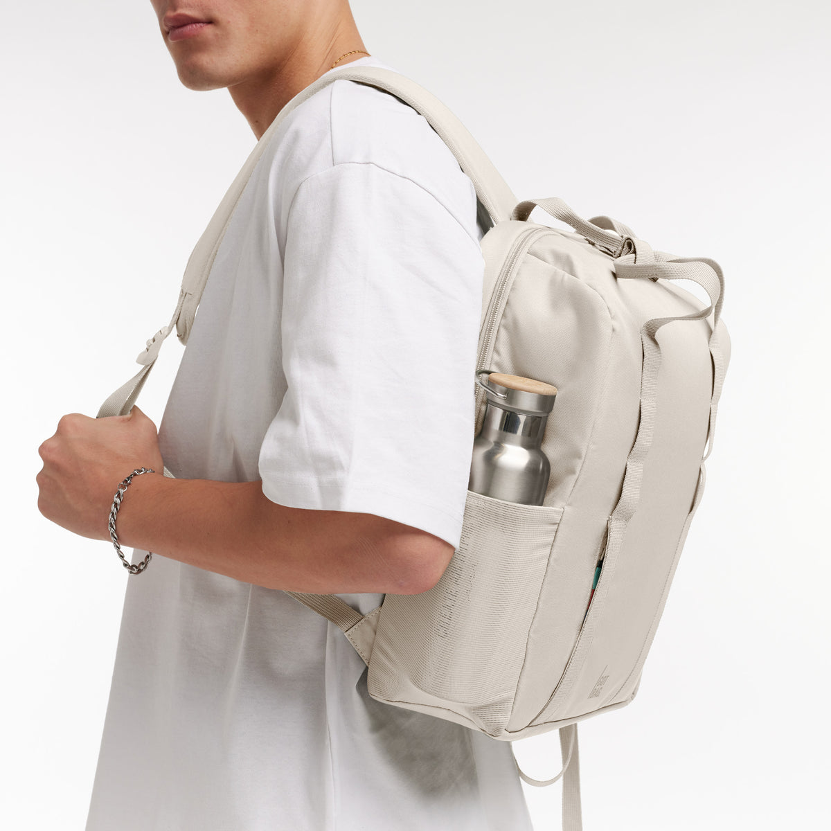 DAYPACK LOOP Rucksack in soft shell (warmes Cremeweiß) von einem Mann auf dem Rücken getragen.