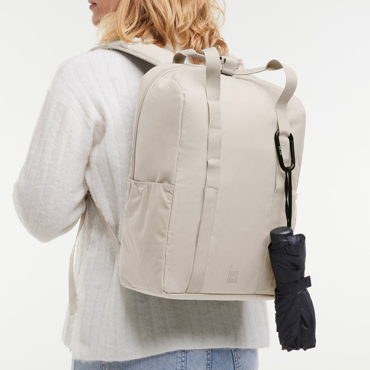 DAYPACK LOOP Rucksack in soft shell (warmes Cremeweiß) von einer Frau auf dem Rücken getragen.