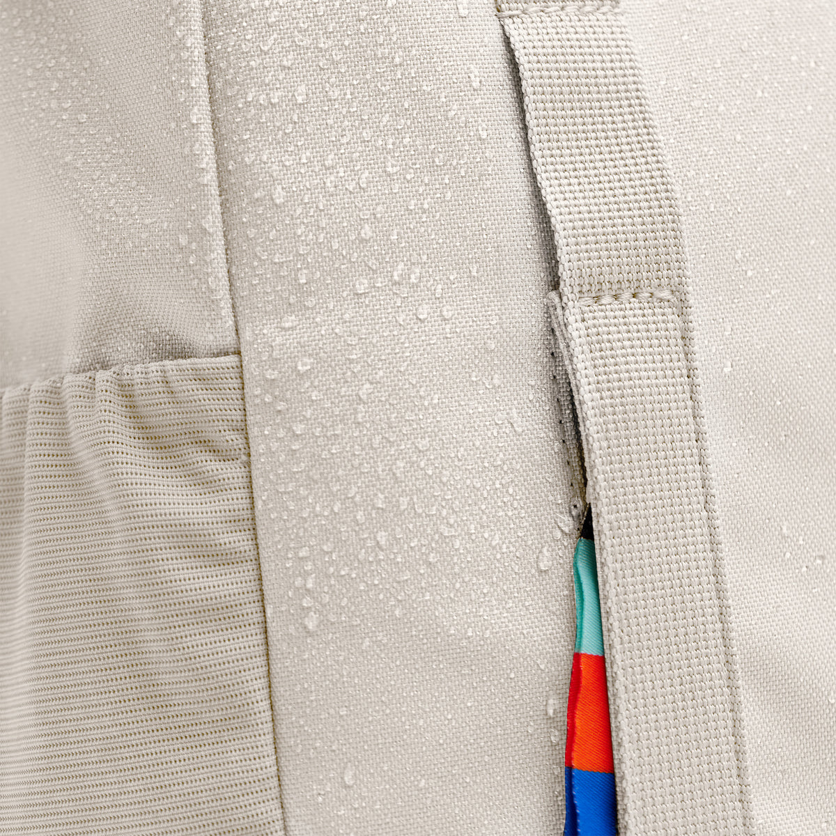 DAYPACK LOOP Rucksack in soft shell (warmes Cremeweiß) als Detailaufnahme mit Wassertropfen auf dem Stoff.