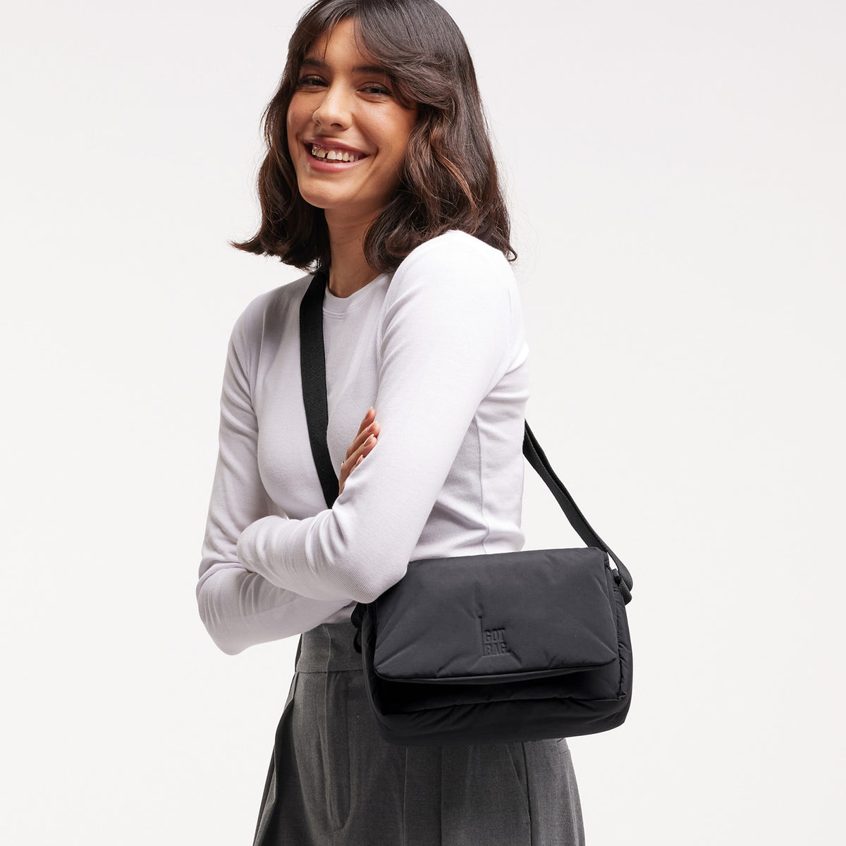 CLOUD CROSSBODY BAG Tasche in black (Schwarz) von einer Frau crossbody getragen.