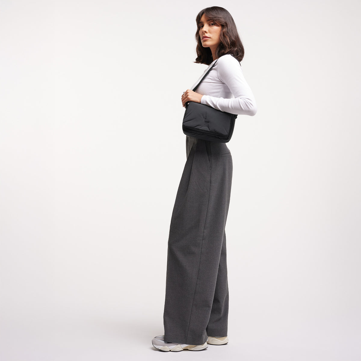 CLOUD CROSSBODY BAG Tasche in black (Schwarz) von einer Frau crossbody getragen.