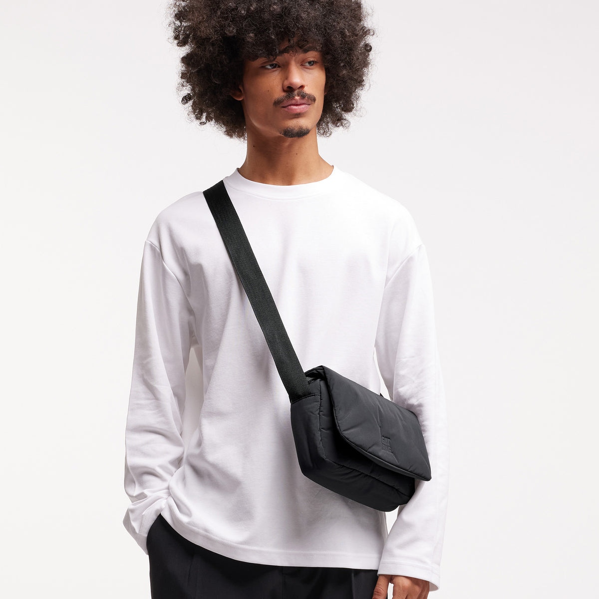 CLOUD CROSSBODY BAG Tasche in black (Schwarz) von einem Mann crossbody getragen.