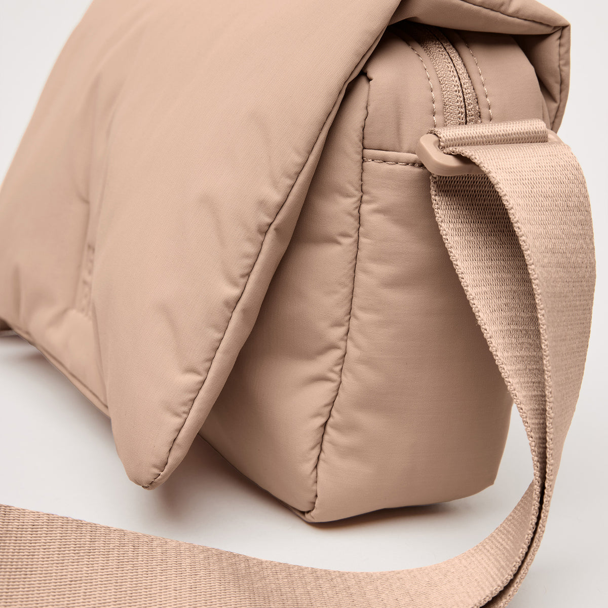 CLOUD CROSSBODY BAG Tasche in sandbar (warmes Beige mit rötlichem Unterton) als Detailaufnahme.