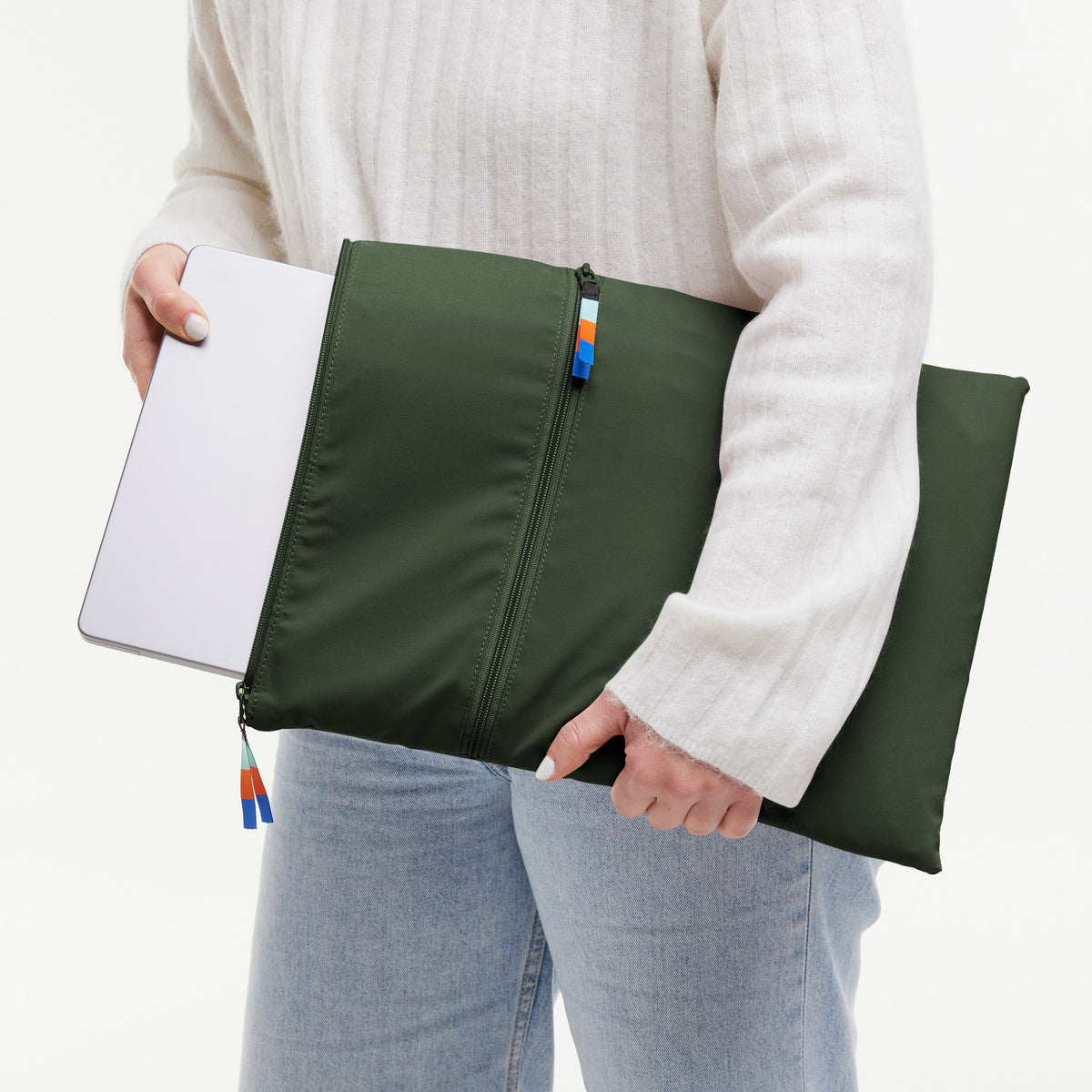 ROLLTOP LITE 2.0 Tasche in algae (Dunkelgrün mit Graustich) von einer Frau in der Hand gehalten.