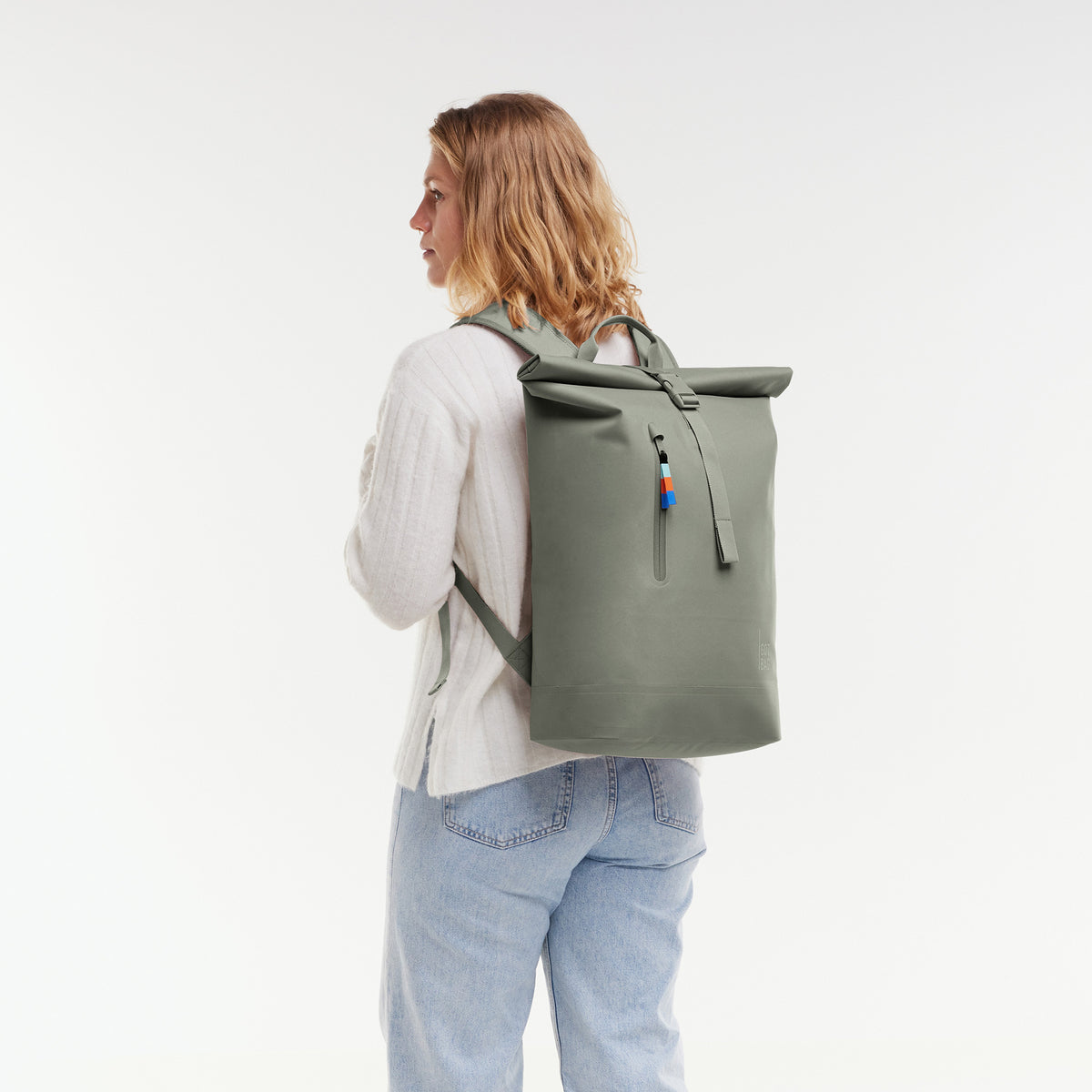 ROLLTOP LITE 2.0 Rucksack in bass (Salbeigrün) von einer Frau als Rucksack auf dem Rücken getragen.