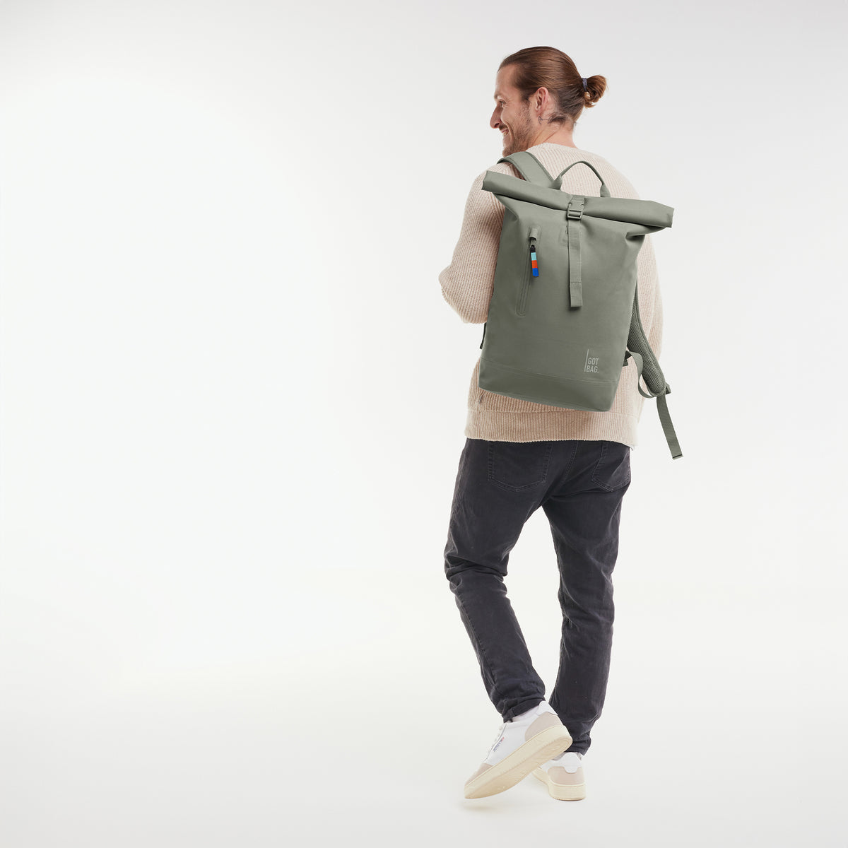 ROLLTOP LITE 2.0 Rucksack in bass (Salbeigrün) von einem Mann auf dem Rücken getragen.