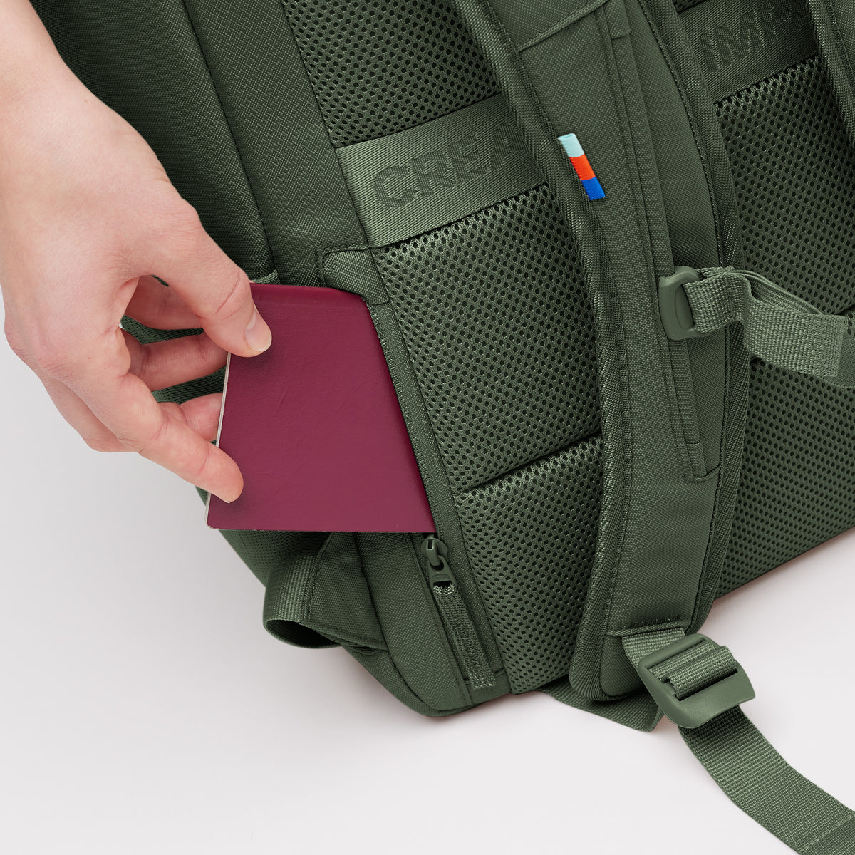 PRO PACK Rucksack in algae (Dunkelgrün mit Graustich), Hand steckt einen Pass in verdeckte Tasche.