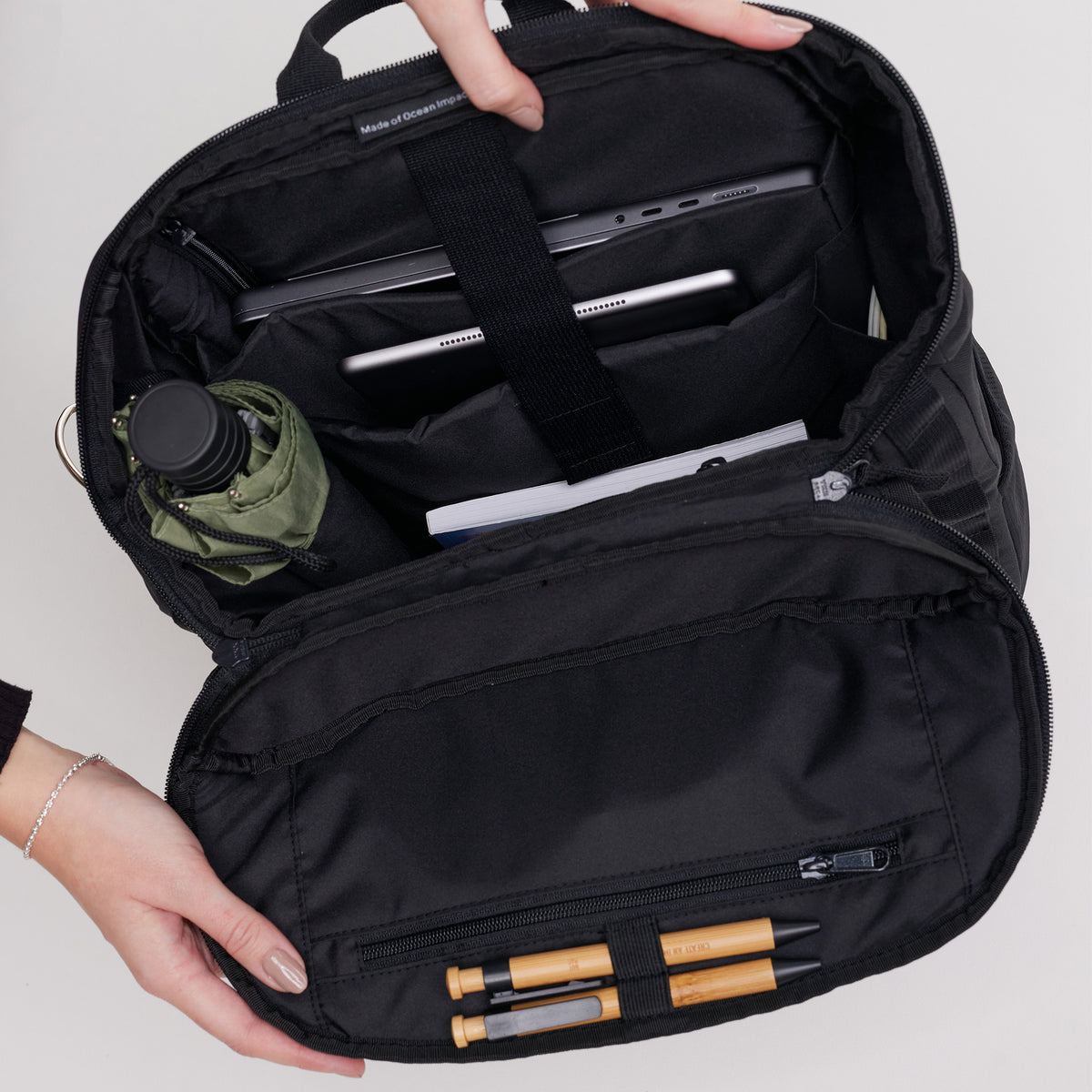 PRO PACK Rucksack in black (Schwarz) von einer Frau geöffnet, die Organisation zeigend.