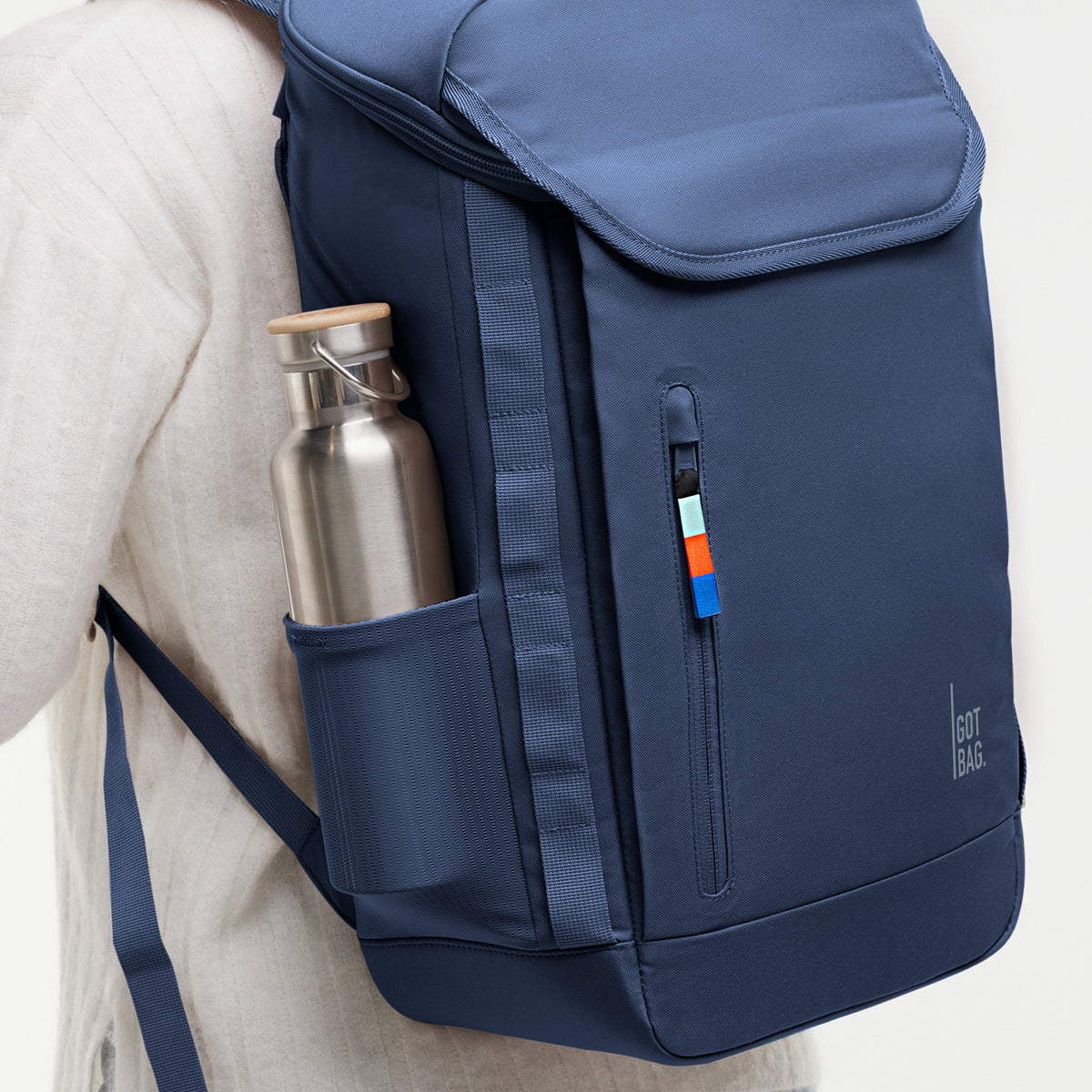PRO PACK Rucksack, von einer Frau auf dem Rücken getragen, mit einer Trinkflasche in der Seitentasche.