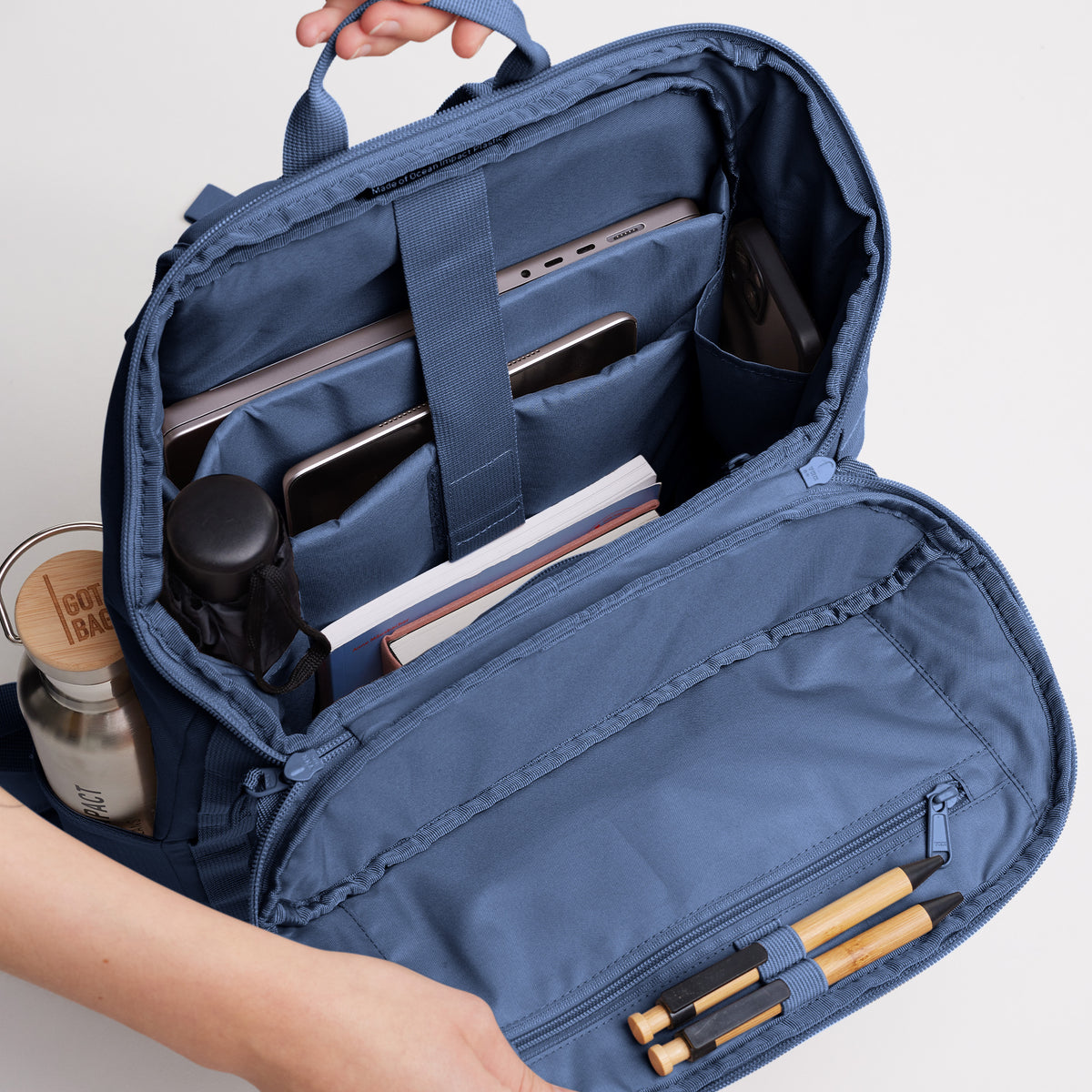 PRO PACK Rucksack als Detailaufnahme der geöffneten Innenansicht, gefüllt mit Laptop, Büchern und Flasche.