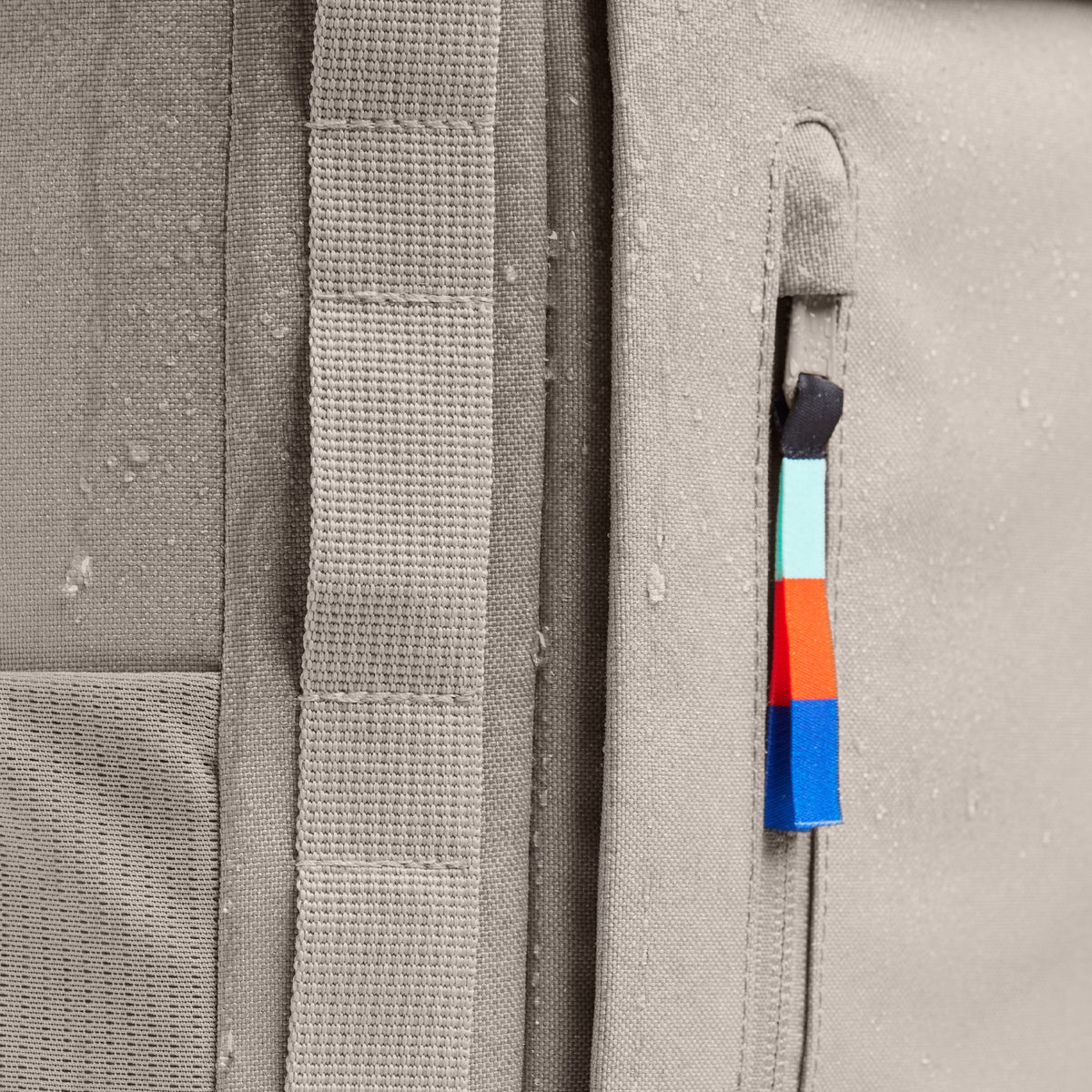 PRO PACK Rucksack in scallop (helles Beige) mit Wassertropfen und farbigem Reißverschluss. Detailaufnahme.
