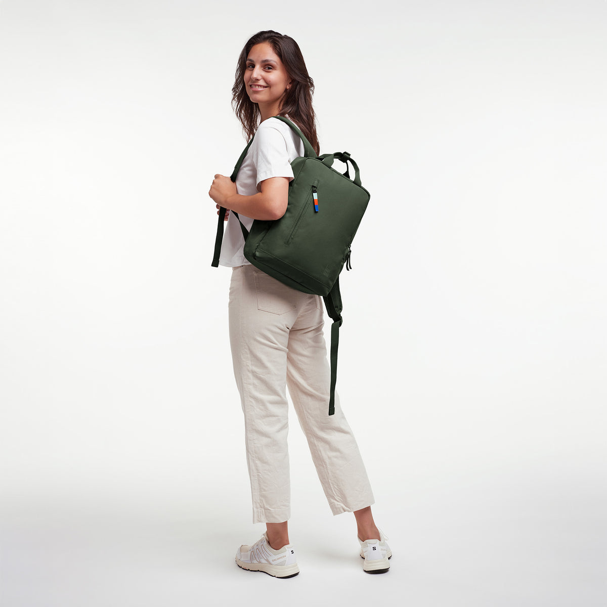 DAYPACK 2.0 Rucksack in algae (Dunkelgrün mit Graustich) von einer Frau auf dem Rücken getragen.
